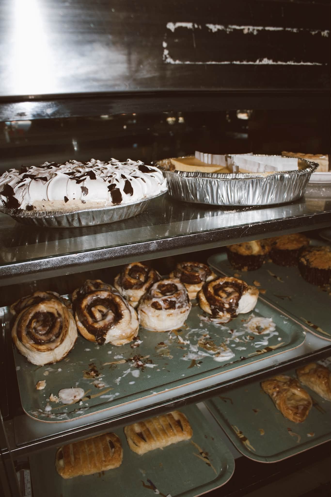 Fresh cinnamon rolls and meringue pie in The Kove display case